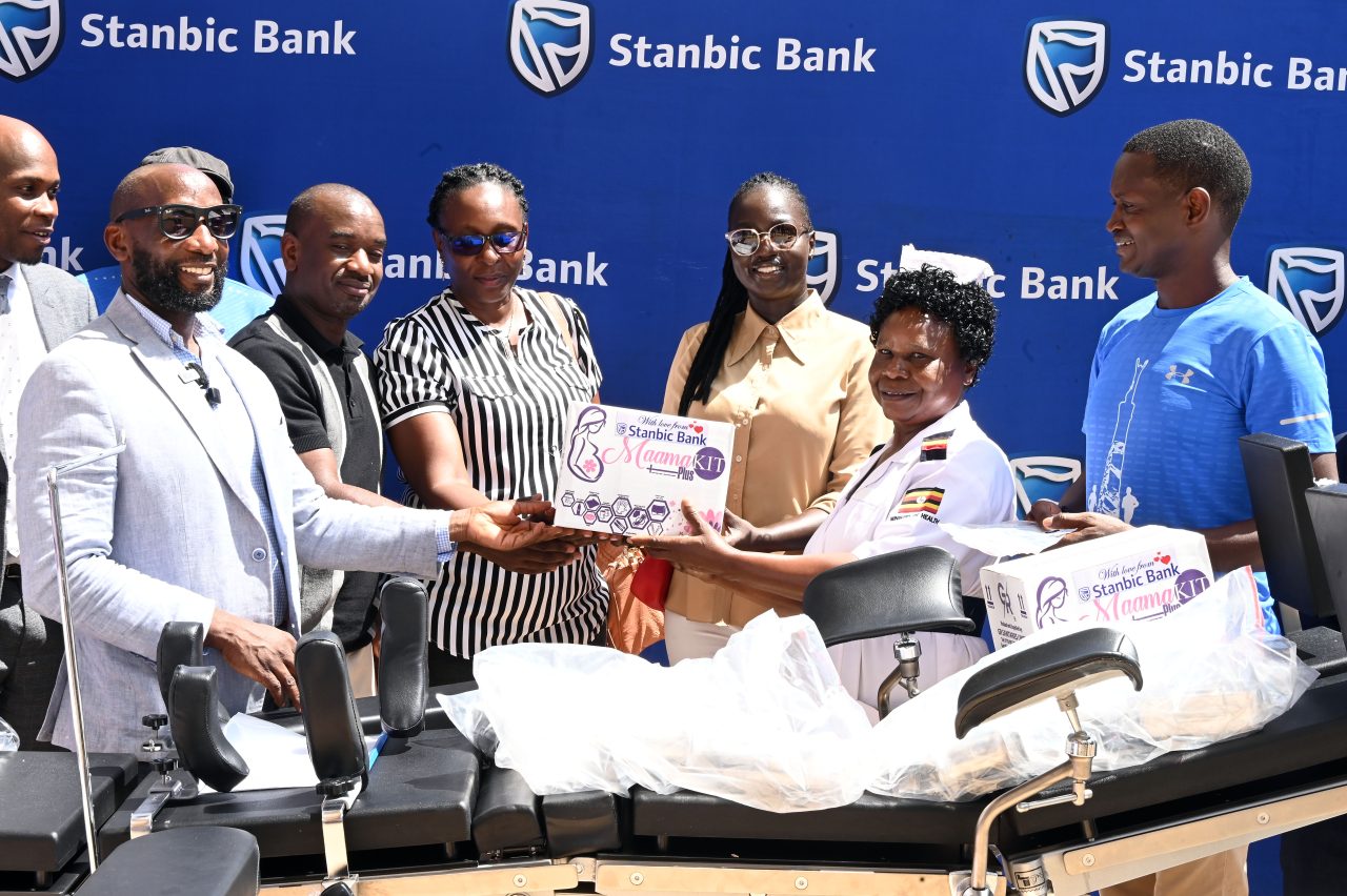 Stanbic Banks Head of Affluent Banking Arthur Kiwanuka left Entebbe Golf Clubs Captain Serwano Walusimbi 2nd left handing over medical equipment to the staff of Entebbe Hospital scaled.